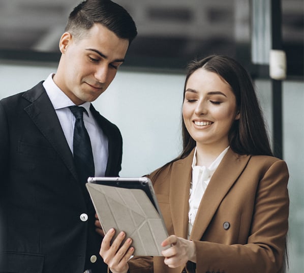 ejecutivos hombre y mujer de traje mirando una tablet ejecutivos hombre y mujer de traje mirando una tablet