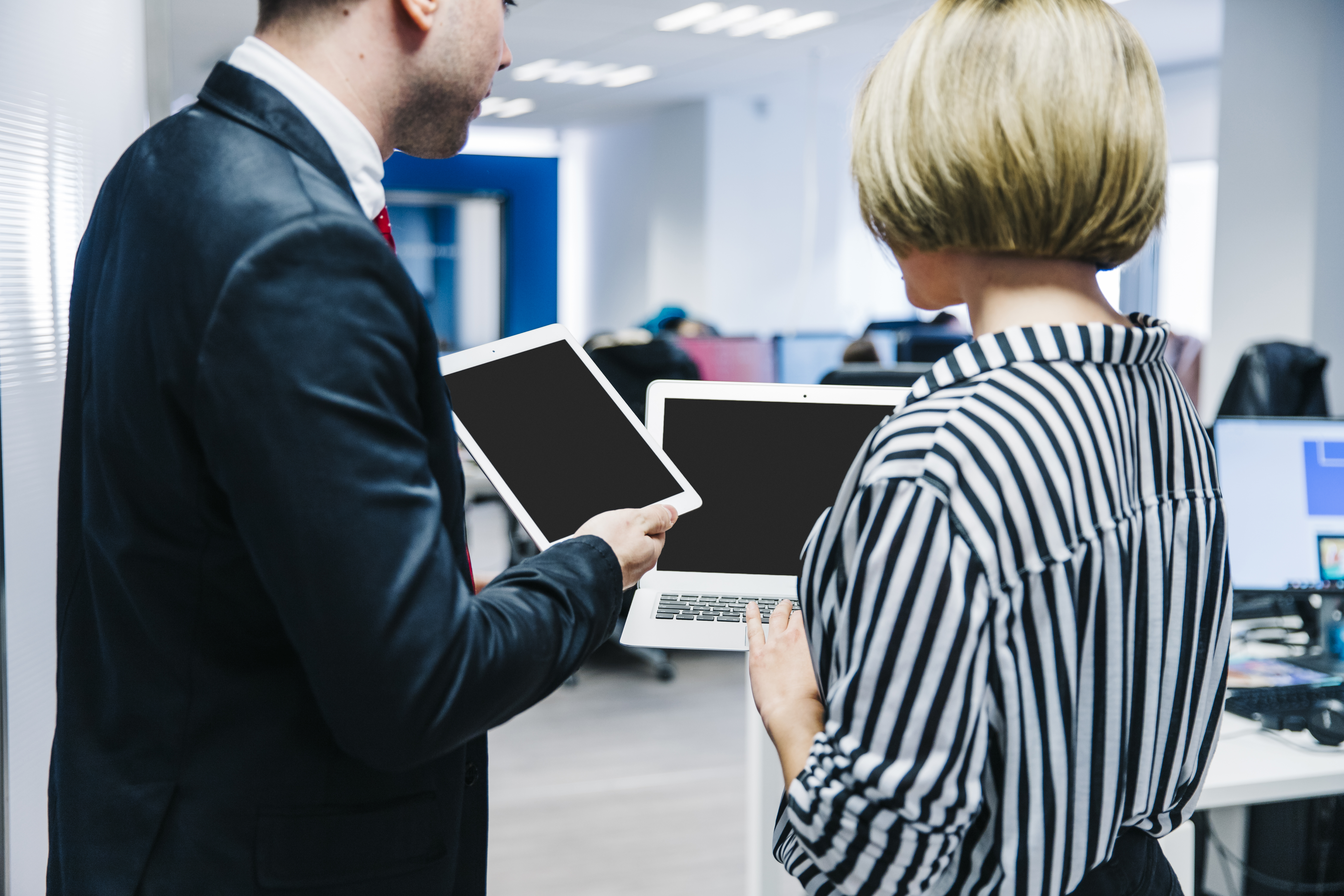 stylish-coworkers-showing-gadgets-each-other